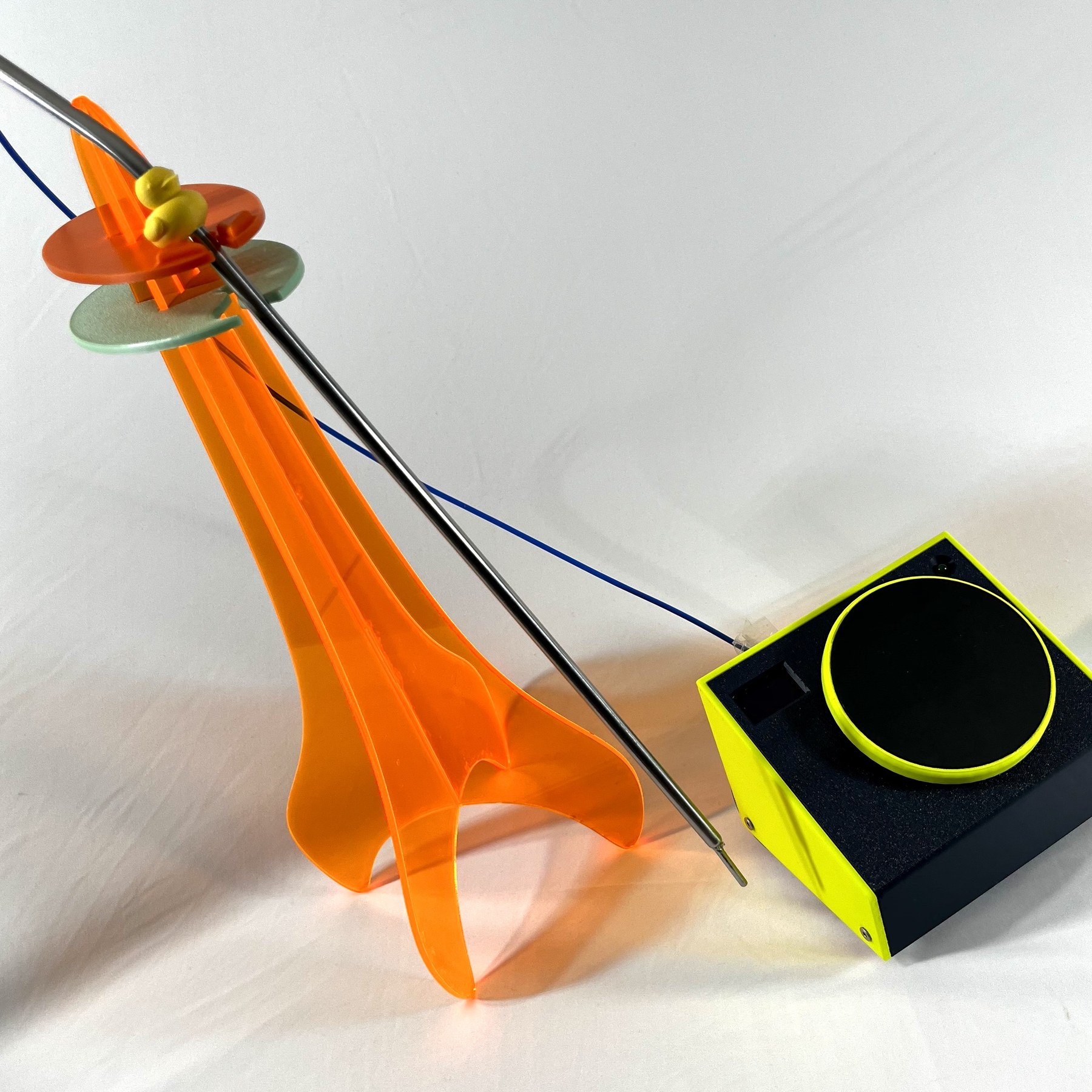 An orange 3D-printed stand holding the thermocouple probe upright