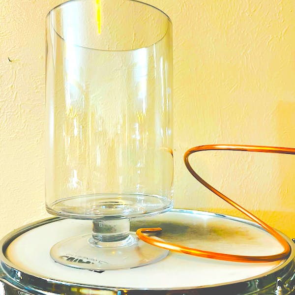 The empty hurricane vase with its copper coil, shown for scale