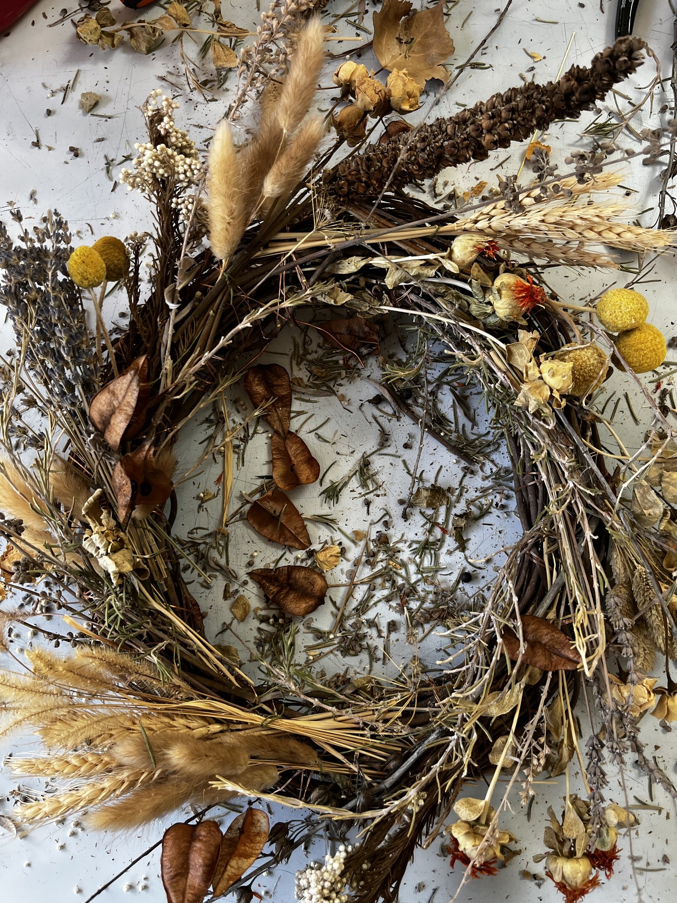 Close view of the dried botanicals — lavender spikes, wheat heads, papery pods and yellow billy buttons