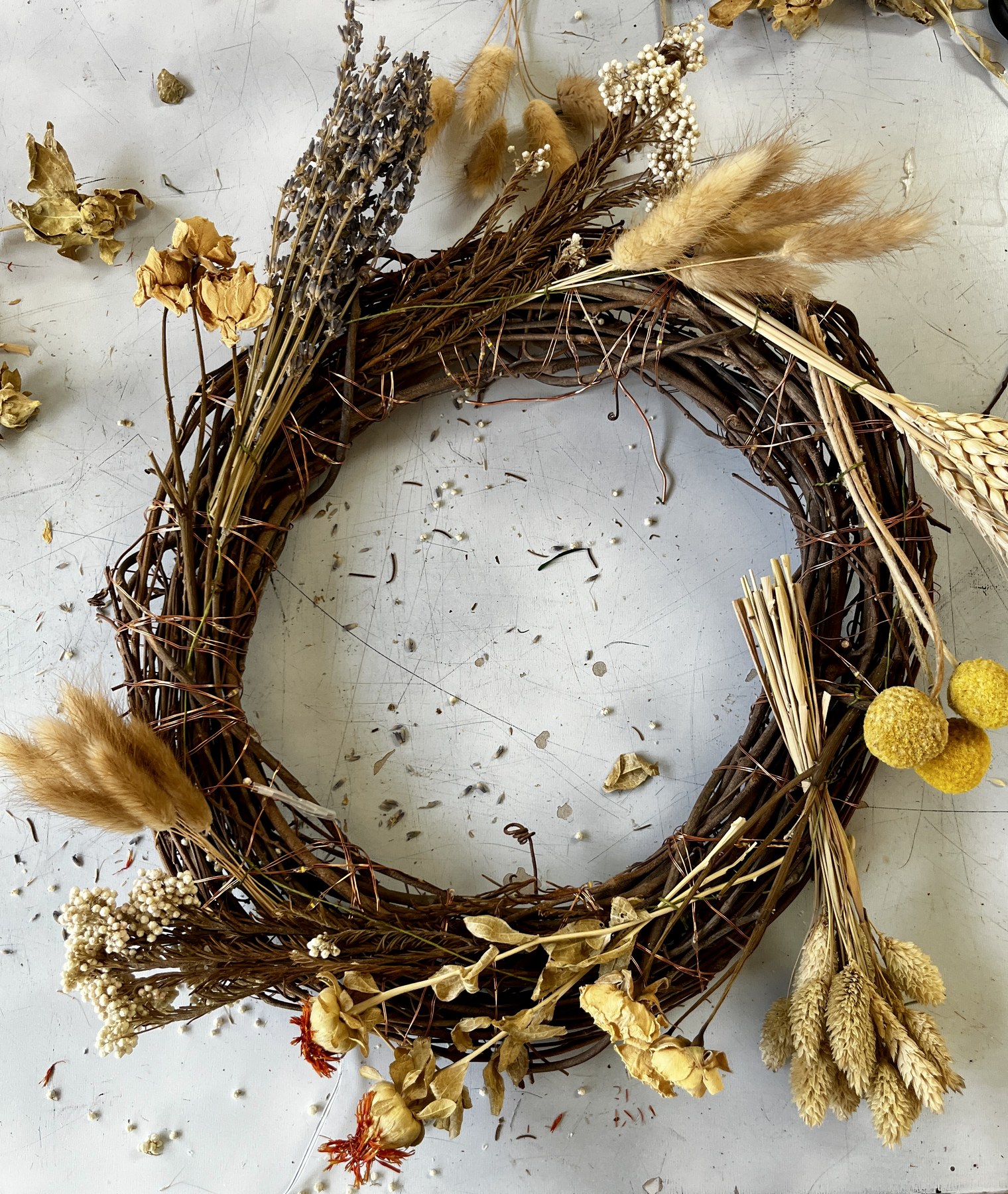 An early stage, the first bundles of dried flowers and grasses wired onto the twig ring