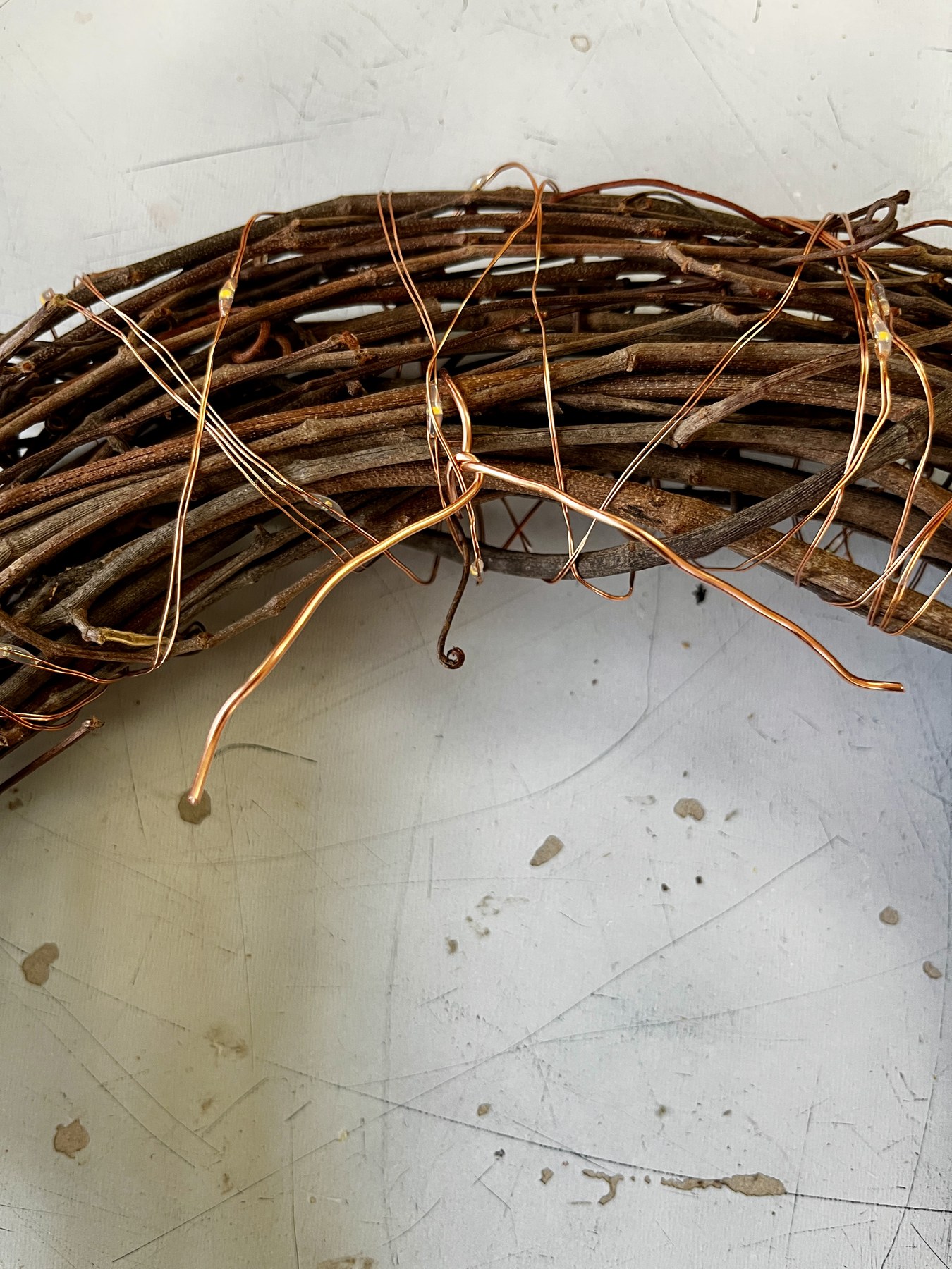 Copper wire wound around the twig base, forming the armature the lights and stems attach to
